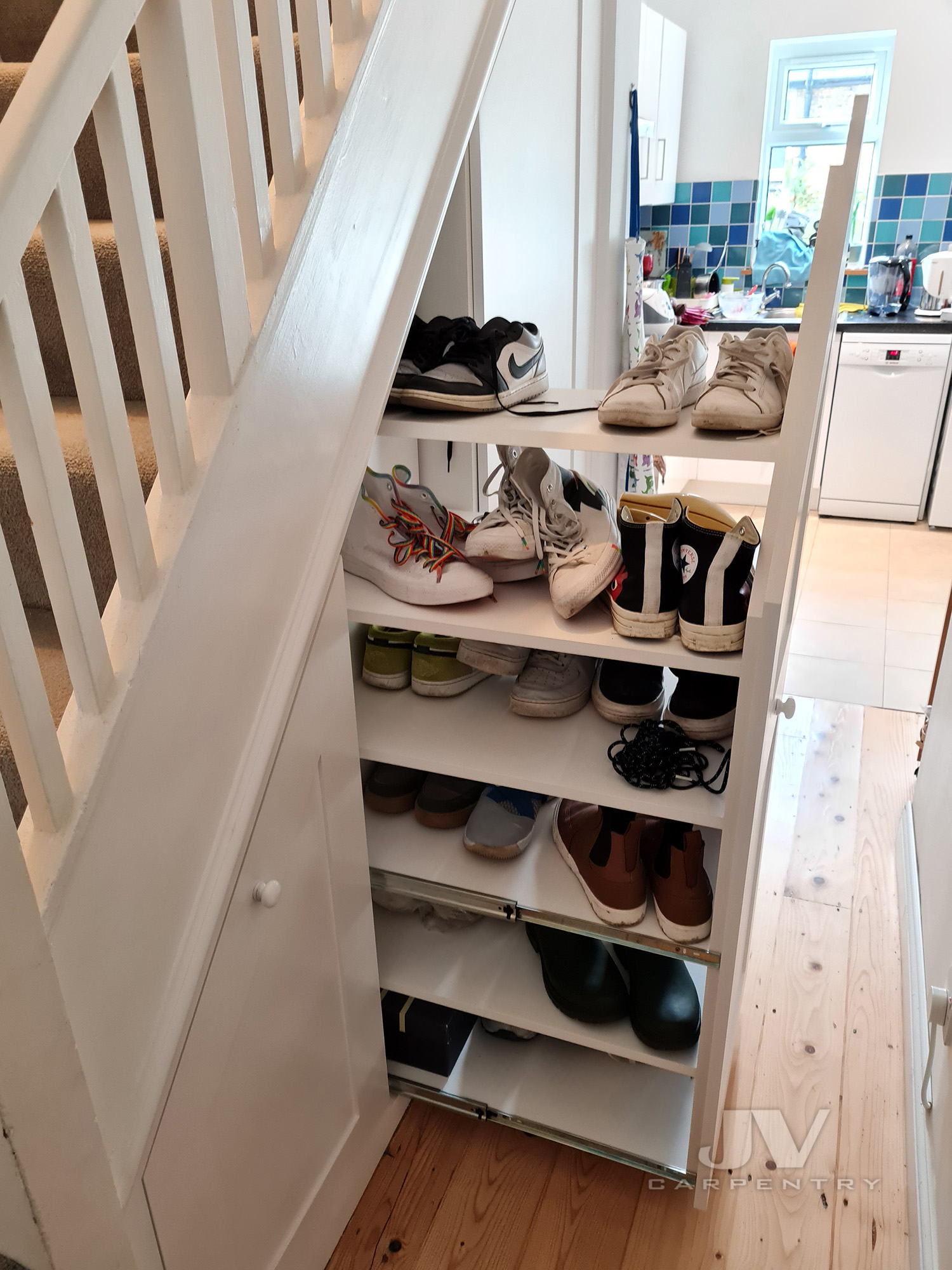 Understairs storage cupboards and drawers installed under a staircase in a London home