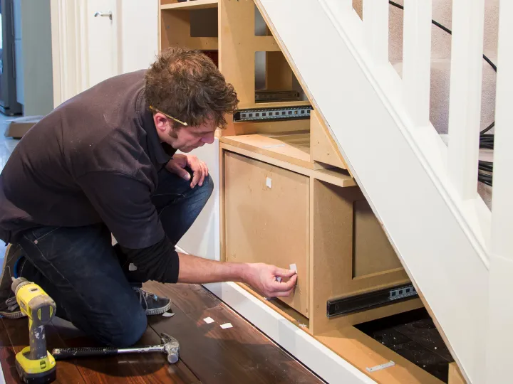 Tall under stairs cupboard and coat storage in a London hallway